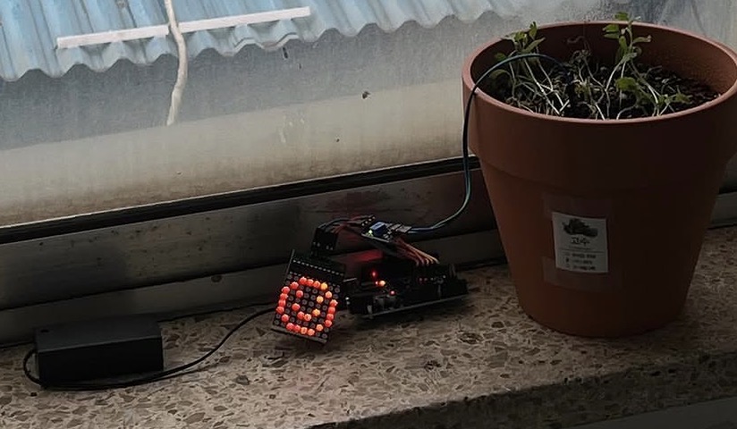 Arduino planter showing a smiling face on LED
